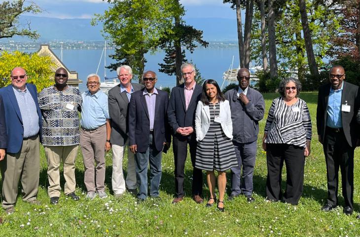 Shailey Prasad stands with partners at the Brocher Colloquium in Geneva. They are all looking toward the camera and smiling
