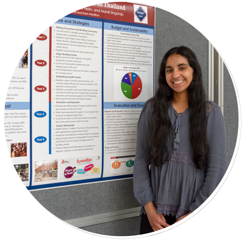 A student stands in front of her poster at Global Health Day